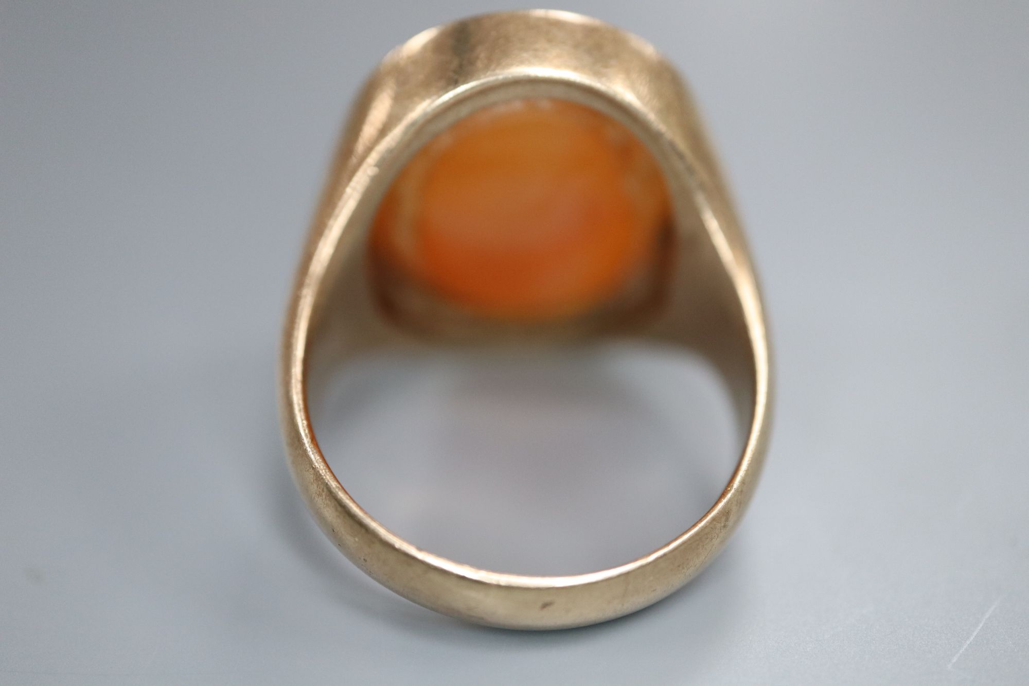 A late 19th century yellow metal and oval carnelian intaglio ring, carved with the head of a gentleman to sinister, size R,